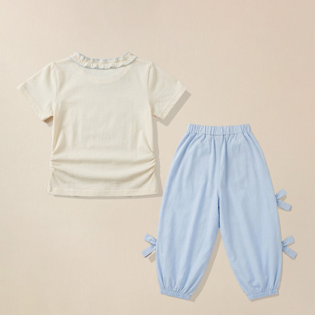Back view of cream ruffle collar t-shirt and blue bow-tie pants set