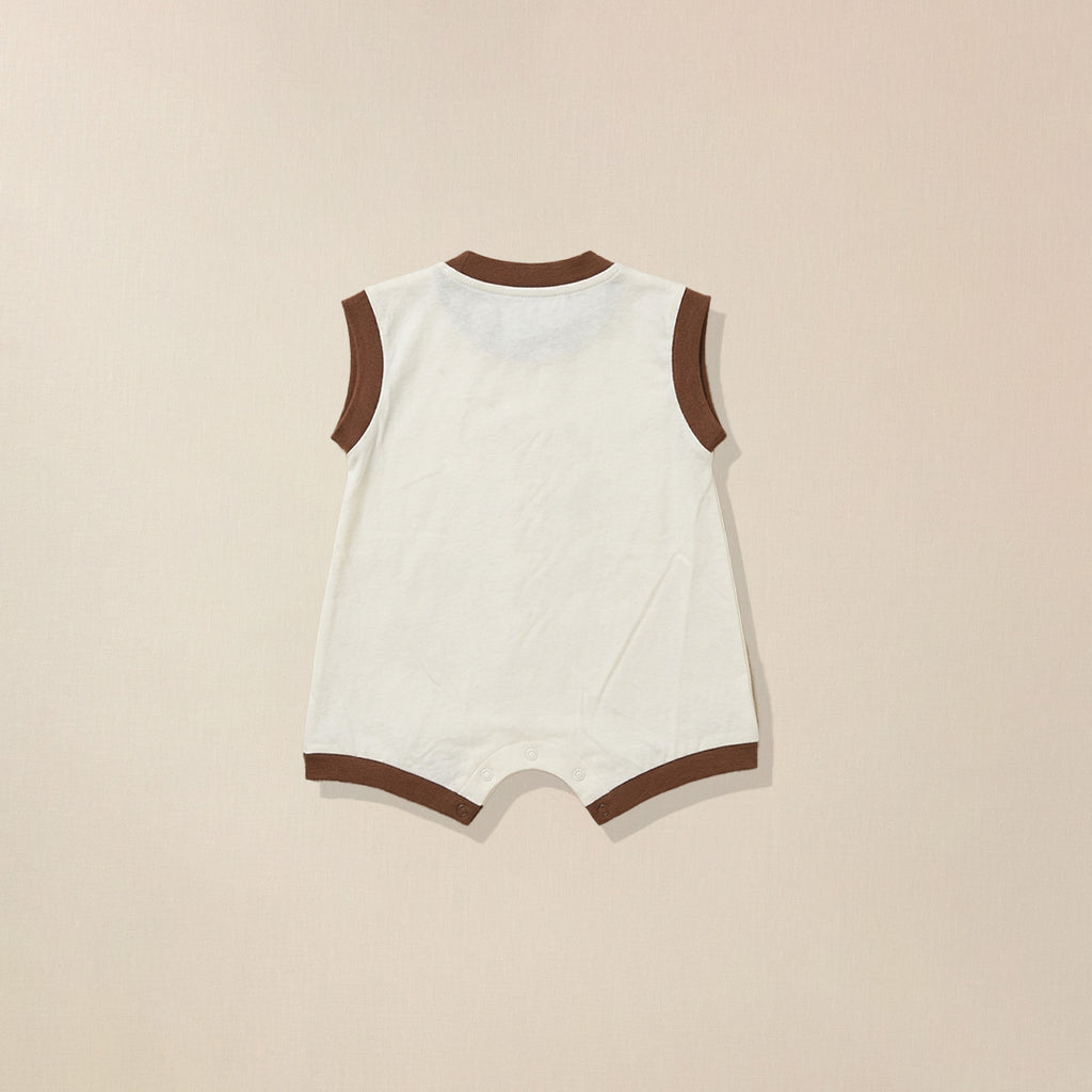 White baby romper with brown trim on a beige background
