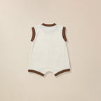 White baby romper with brown trim on a beige background
