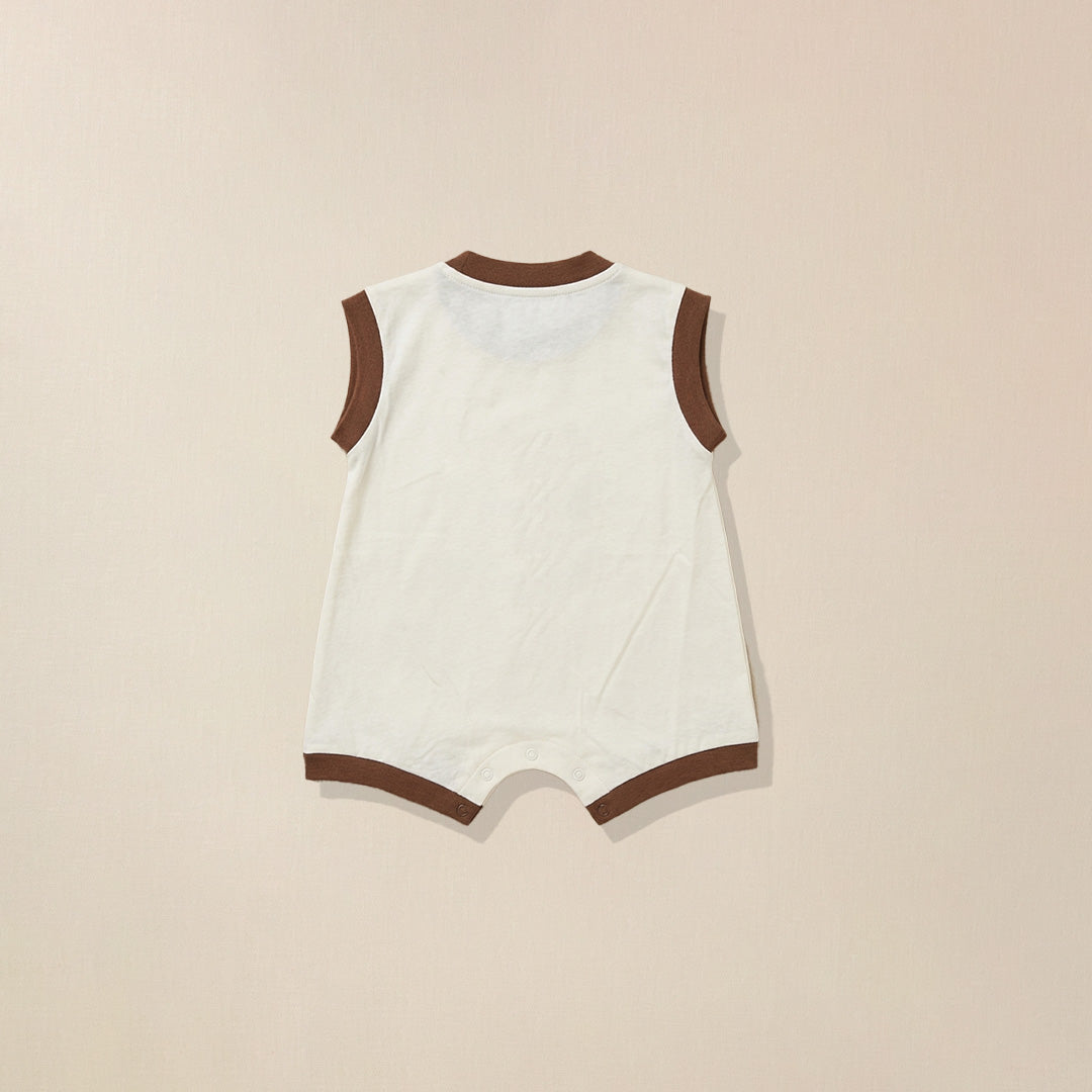 White baby romper with brown trim on a beige background