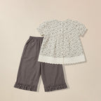 Floral blouse and gray pants on a beige background