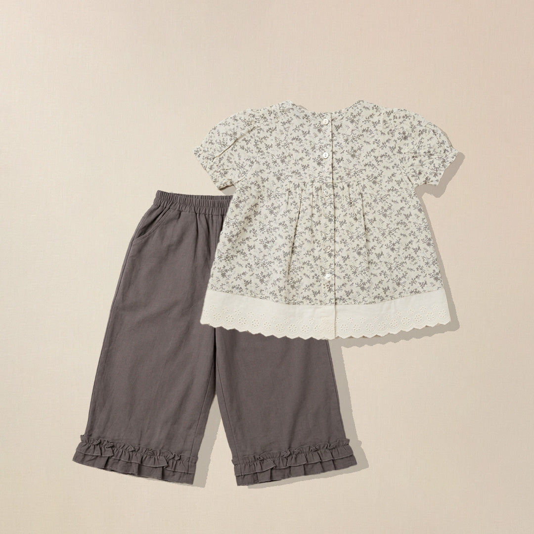 Floral blouse and gray pants on a beige background