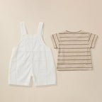 White overalls and striped shirt on a beige background