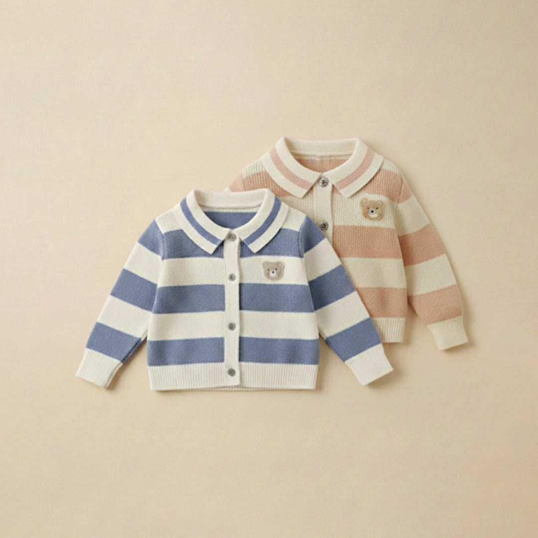 Two children's cardigans, one striped blue and white, the other striped pink and white, on a beige background.